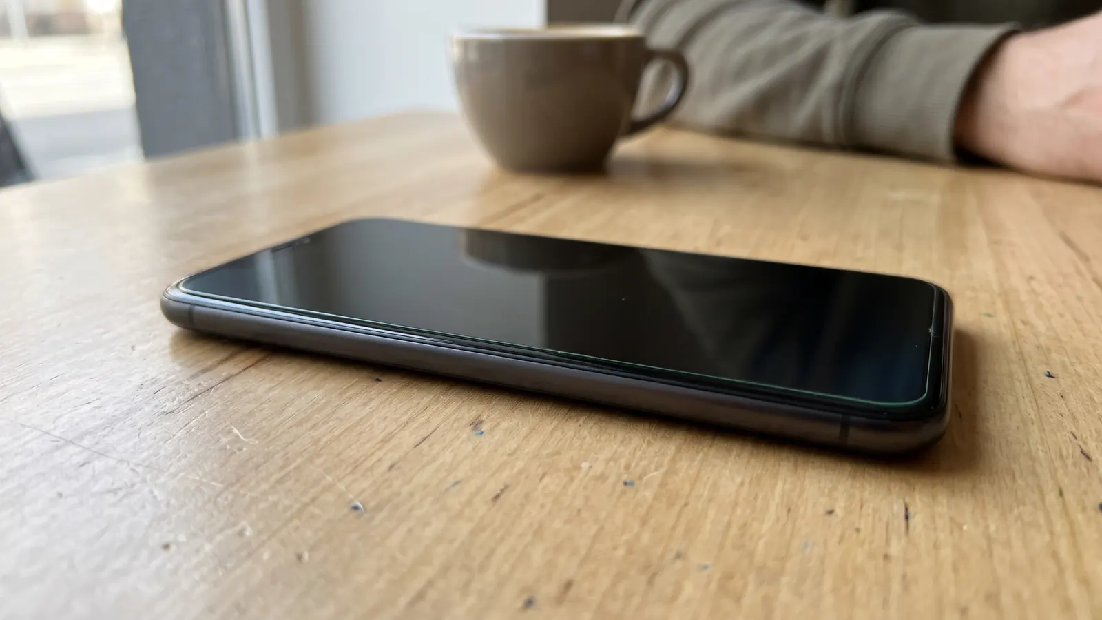 Phone with a privacy screen protector looking dark from the side on a cafe table