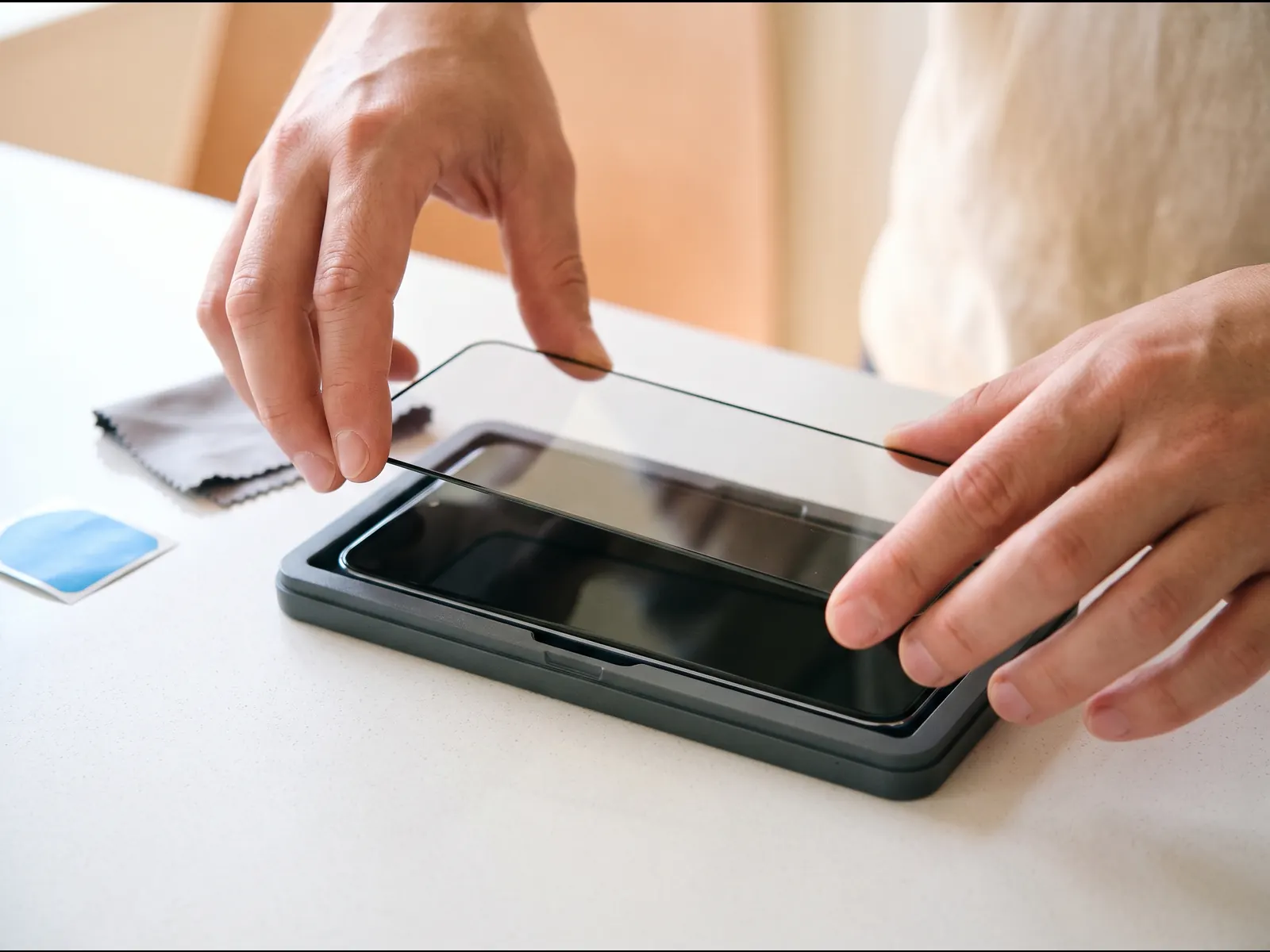 Tempered glass screen protector being lined up on a phone screen